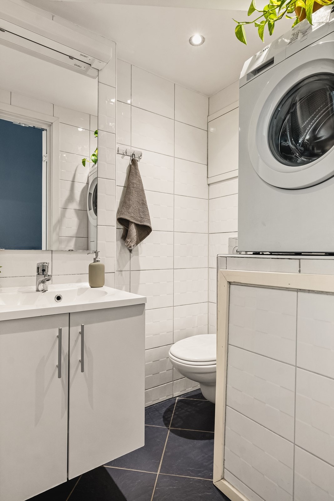 Bad er innredet med dusj, servant i møblement, speil og vegghengt toalett. Spotter i tak, varmekabler i gulv. Galleribilde