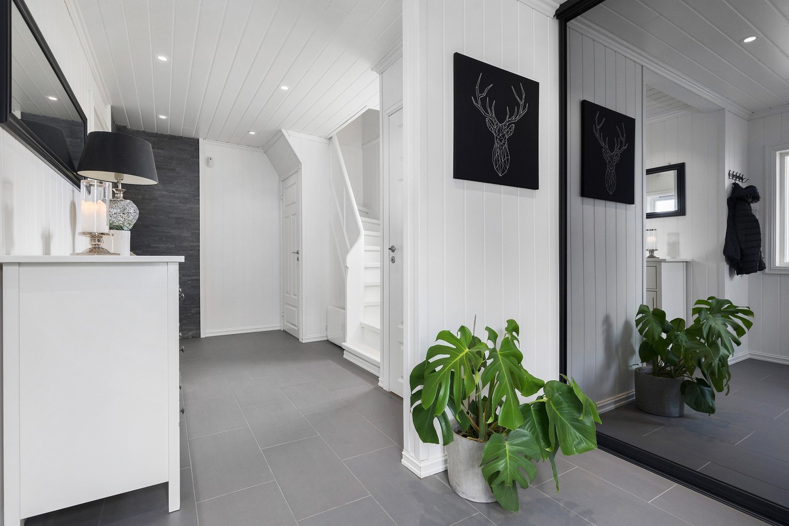 Innbydende gang med flislagt gulv og skyvedørsgarderobe Galleribilde
