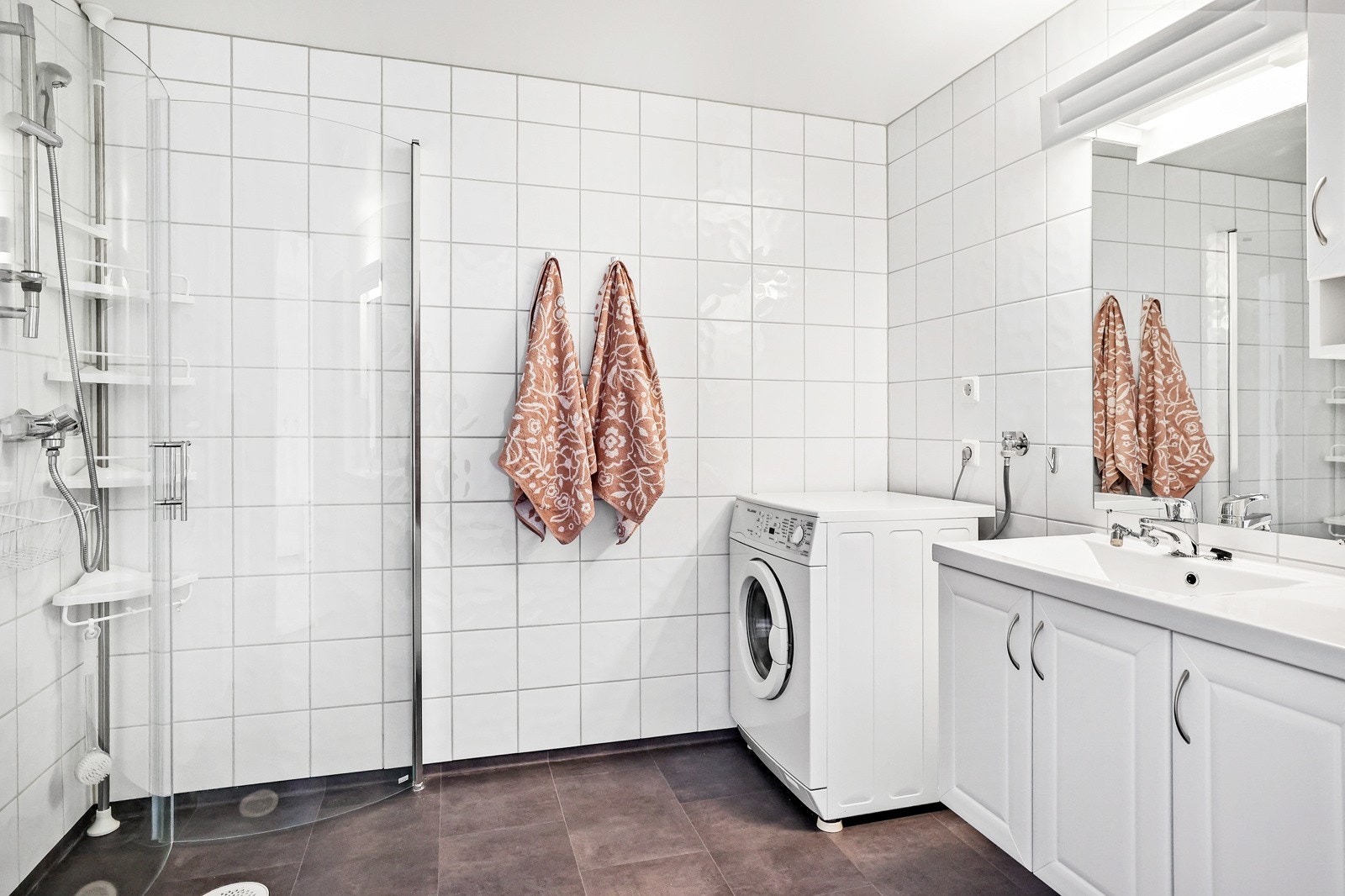Badet er av god størrelse og har flislagte vegger og gulv Galleribilde