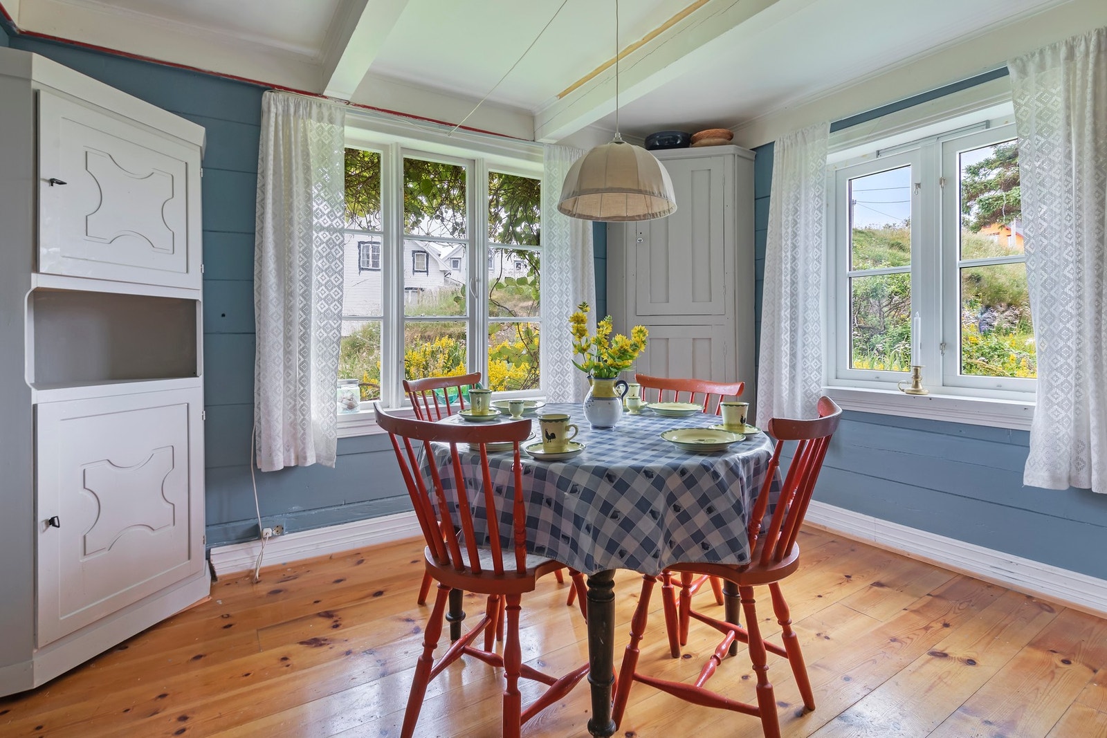 Kjøkkenet har lakkert gulv av plank og malte tømmervegger i fin blåfarge Galleribilde