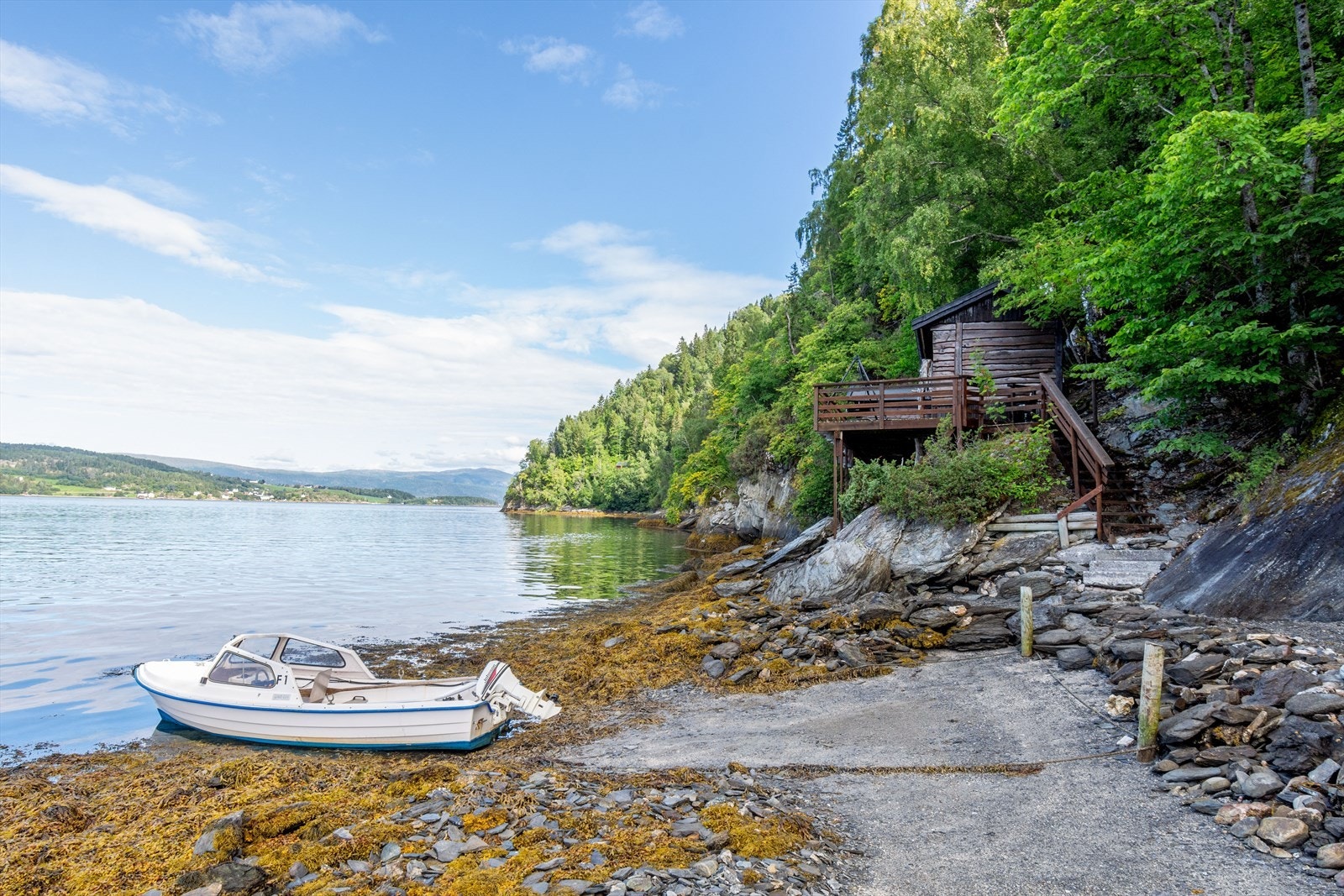 Det er et eget område som er tilrettelagt for landgang med båt. I bakrunnen ser man trappen opp til fritidsboligen Galleribilde