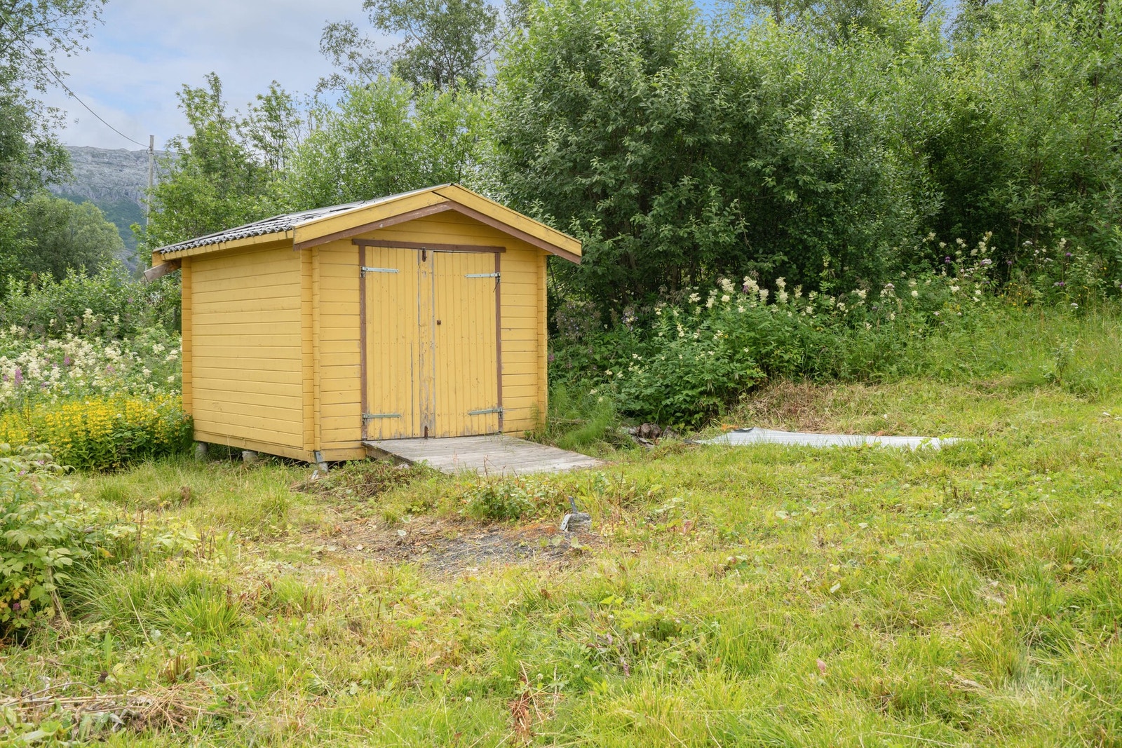 Praktisk uthus med lagringsmuligheter. Like ved finner man også en del bringebærbusker. Galleribilde