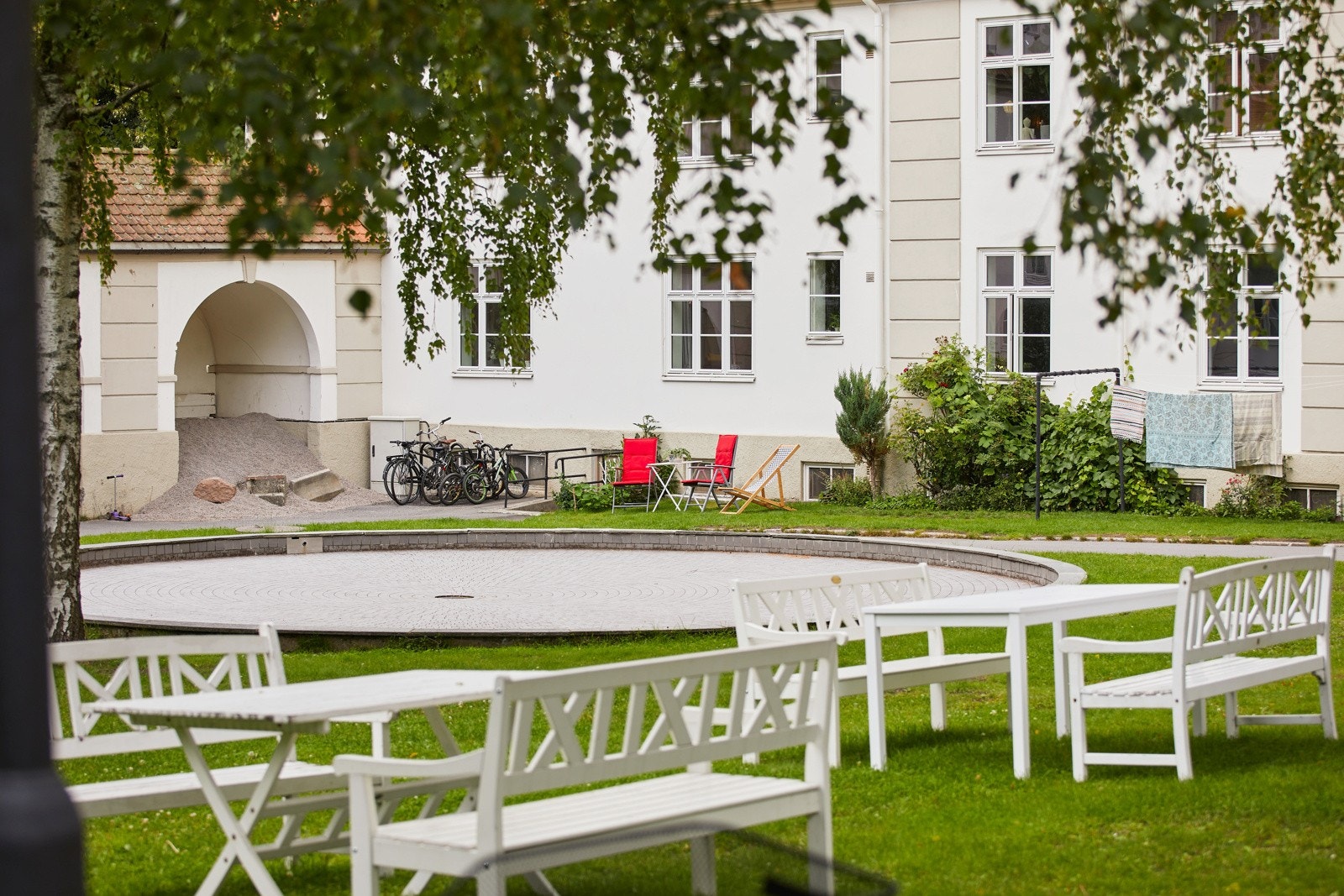 Felles tomt opparbeidet med blant annet asfaltert adkomst, gressplen, trær, prydbusker og diverse beplantning. Galleribilde