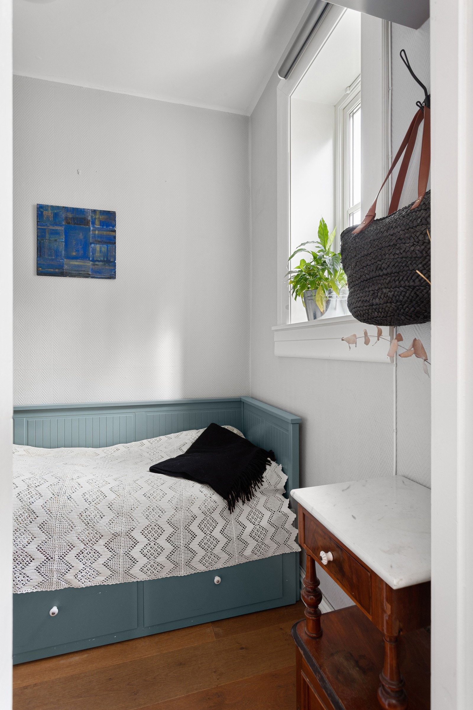 Leiligheten har et lyst og koselig soverom med lysmalte overflater. Galleribilde