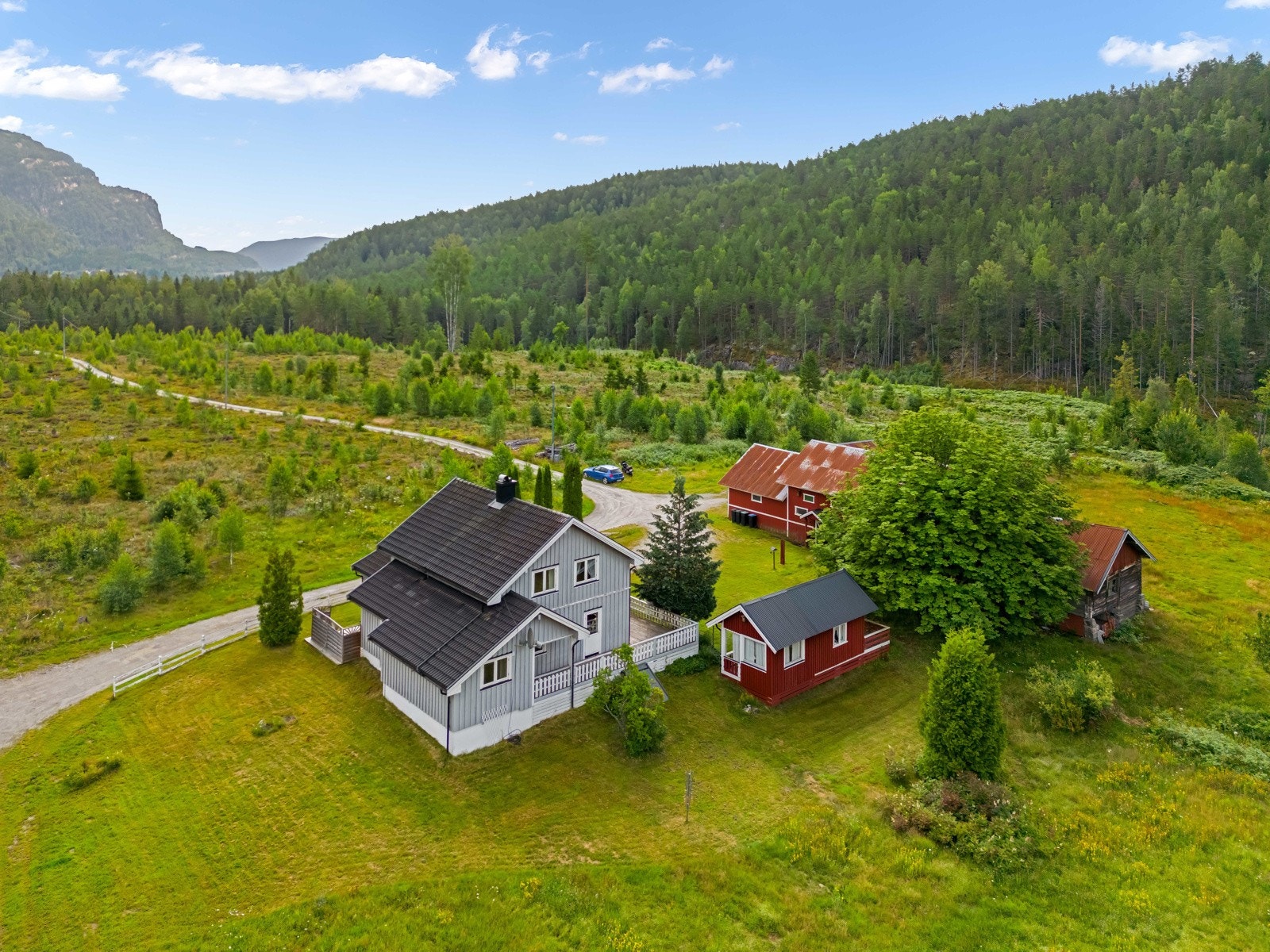 Idyllisk småbruk med våningshus, låve og eldhus. Galleribilde
