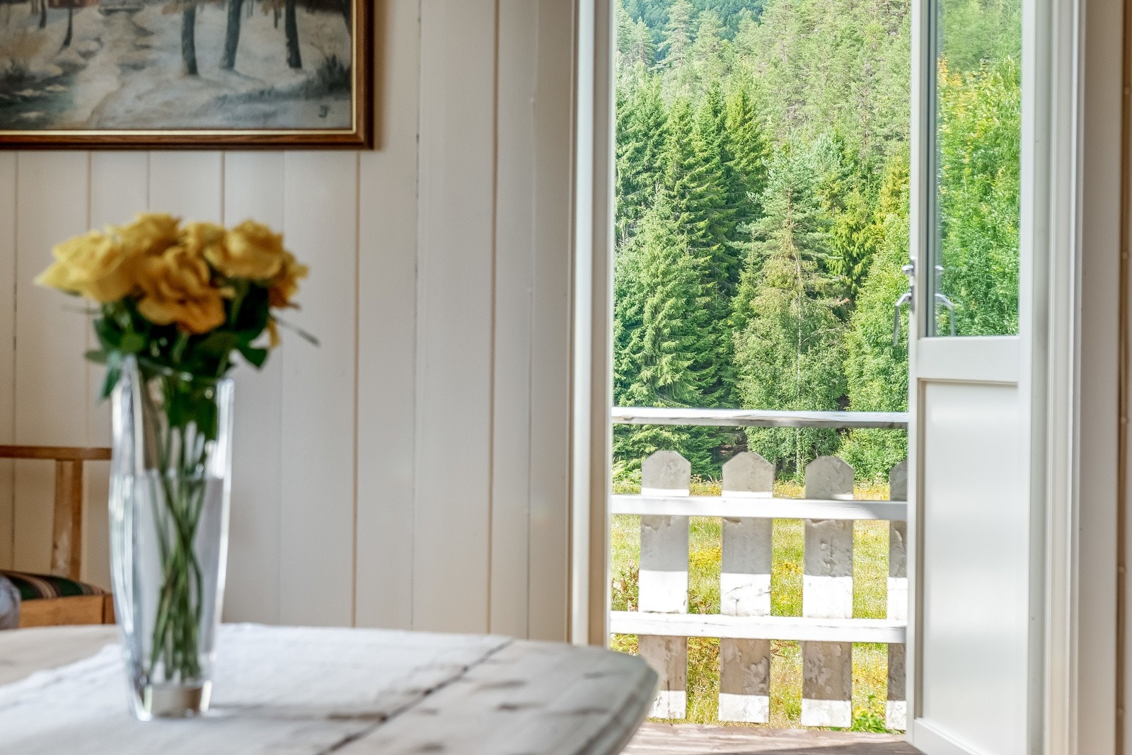 Utgang fra stue via verandadør med glass til romslig veranda med delvis overbygg. Galleribilde