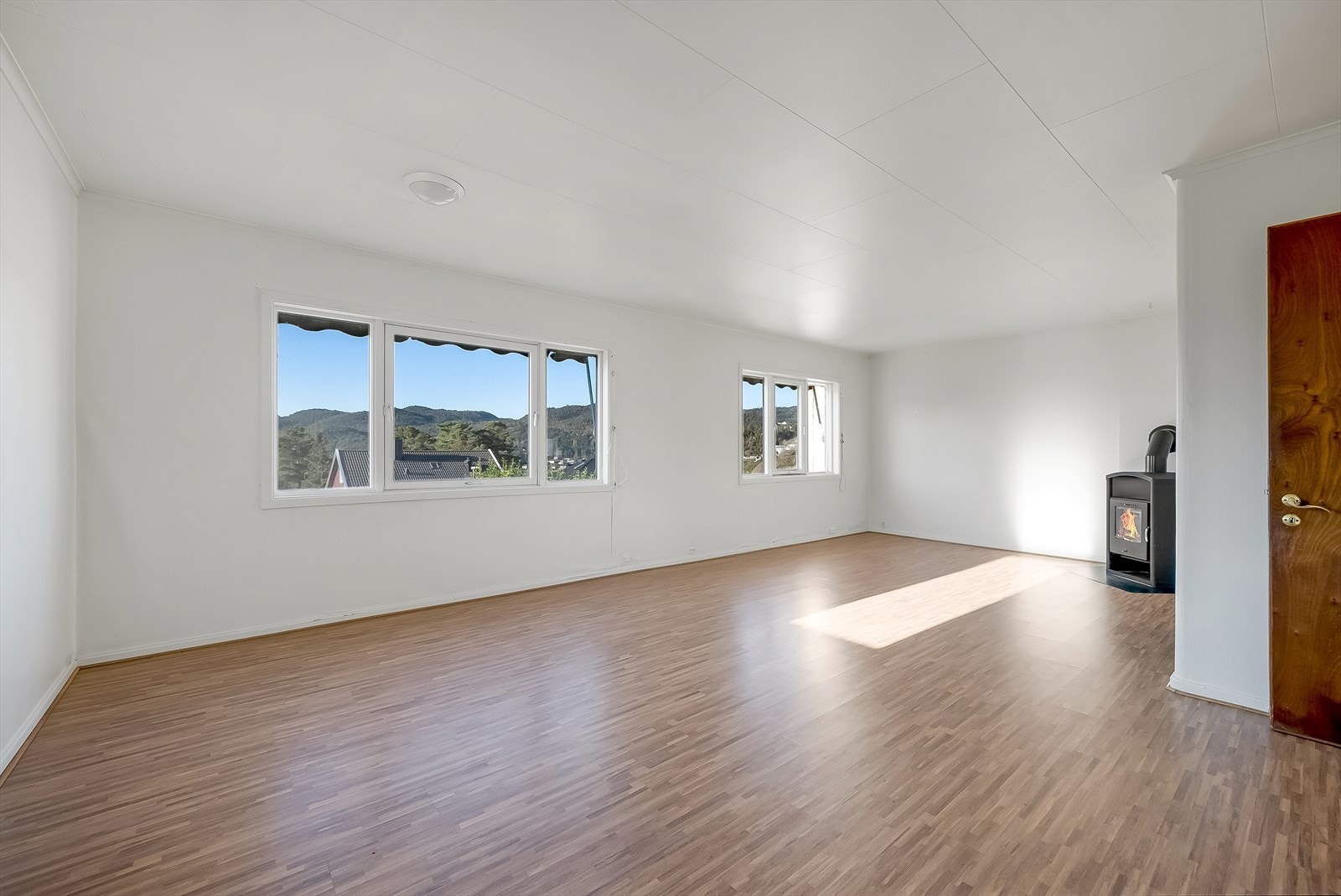 Gulvet er belagt med laminat, kombinert med lyse vegger og takplater. Galleribilde