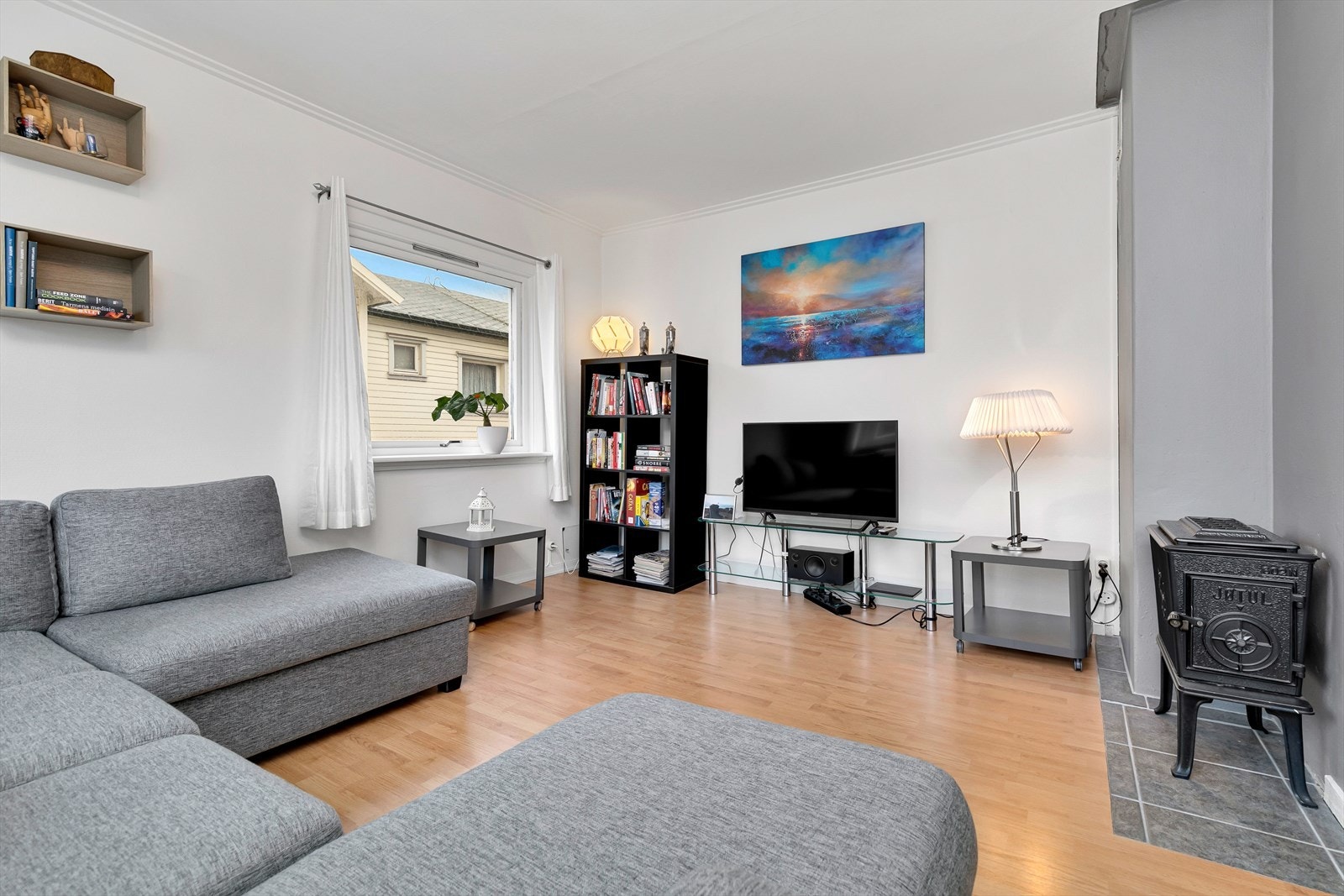 Her står en peisovn av typen Jøtul på keramiske fliser som gir lun og god varme Galleribilde