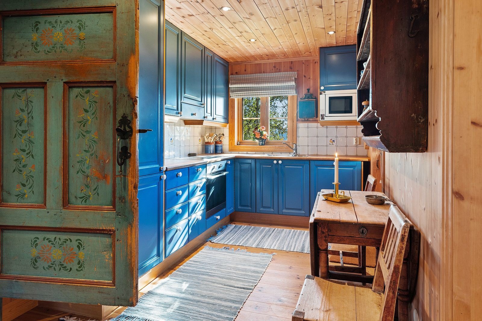 Nydelig gammel dør fører inn til kjøkken med mye skapplass. Galleribilde