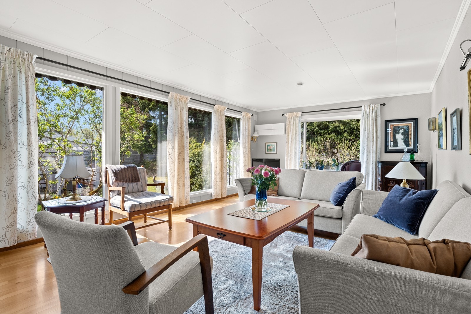 Romslig stue med store vinduer mot hage. Galleribilde