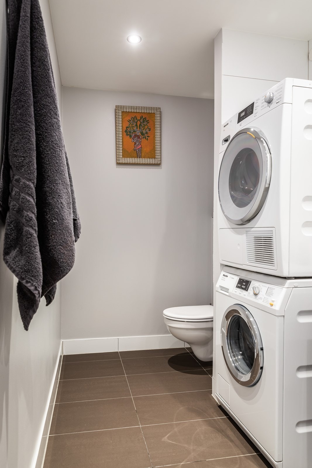 Romslig baderom med opplegg til vaskemaskin og tørketrommel. Galleribilde