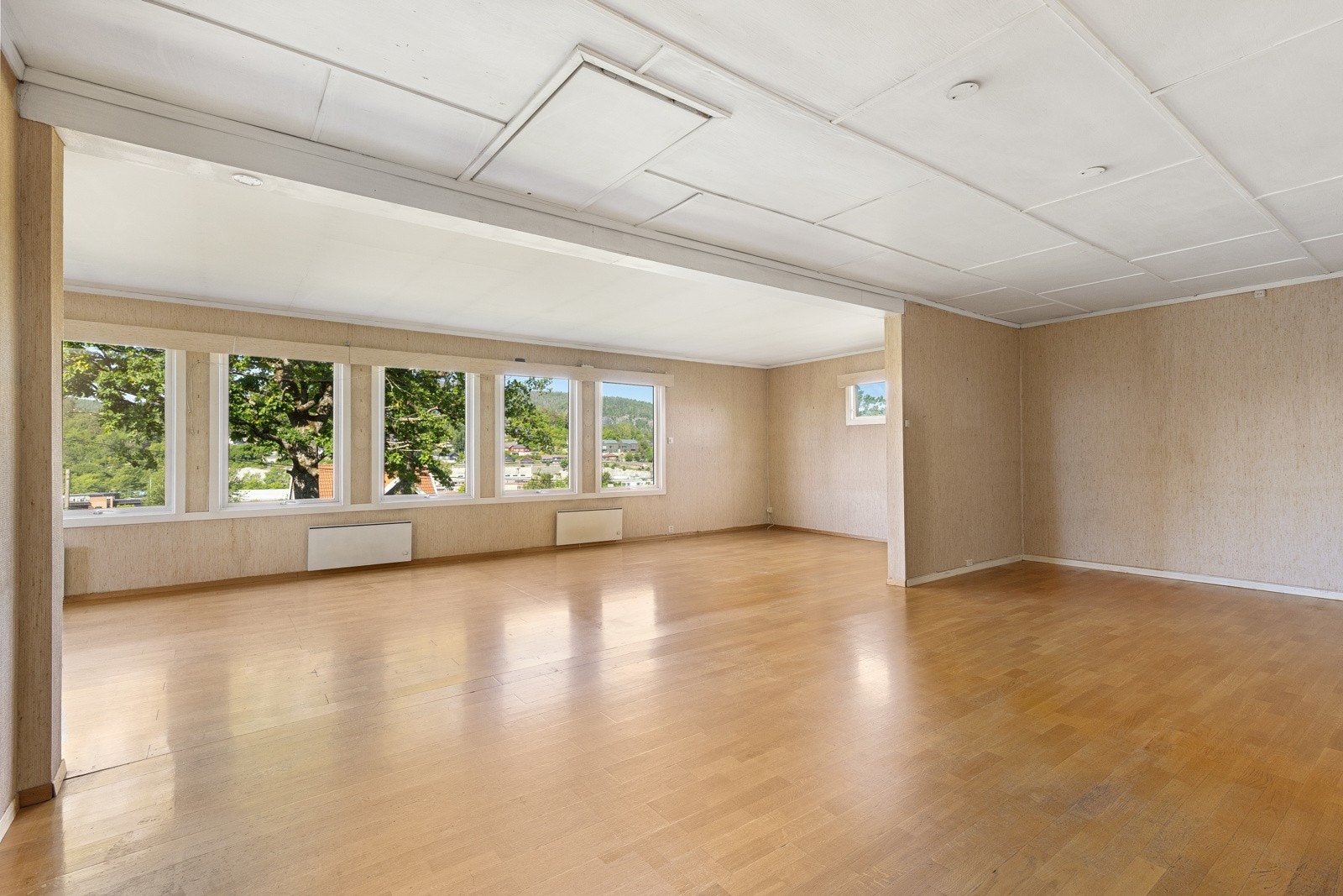 Åpent og romslig oppholdsrom med store vindusflater som slipper inn rikelig med dagslys Galleribilde