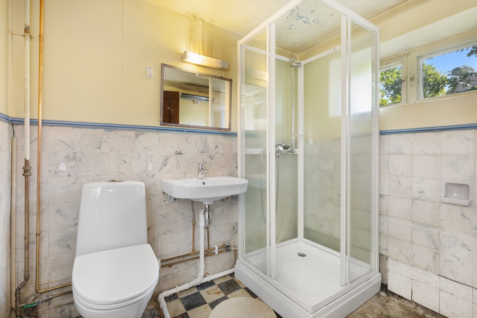 Badet i underetasjen er innredet med gulvstående klosett, servant og dusjkabinett. Galleribilde