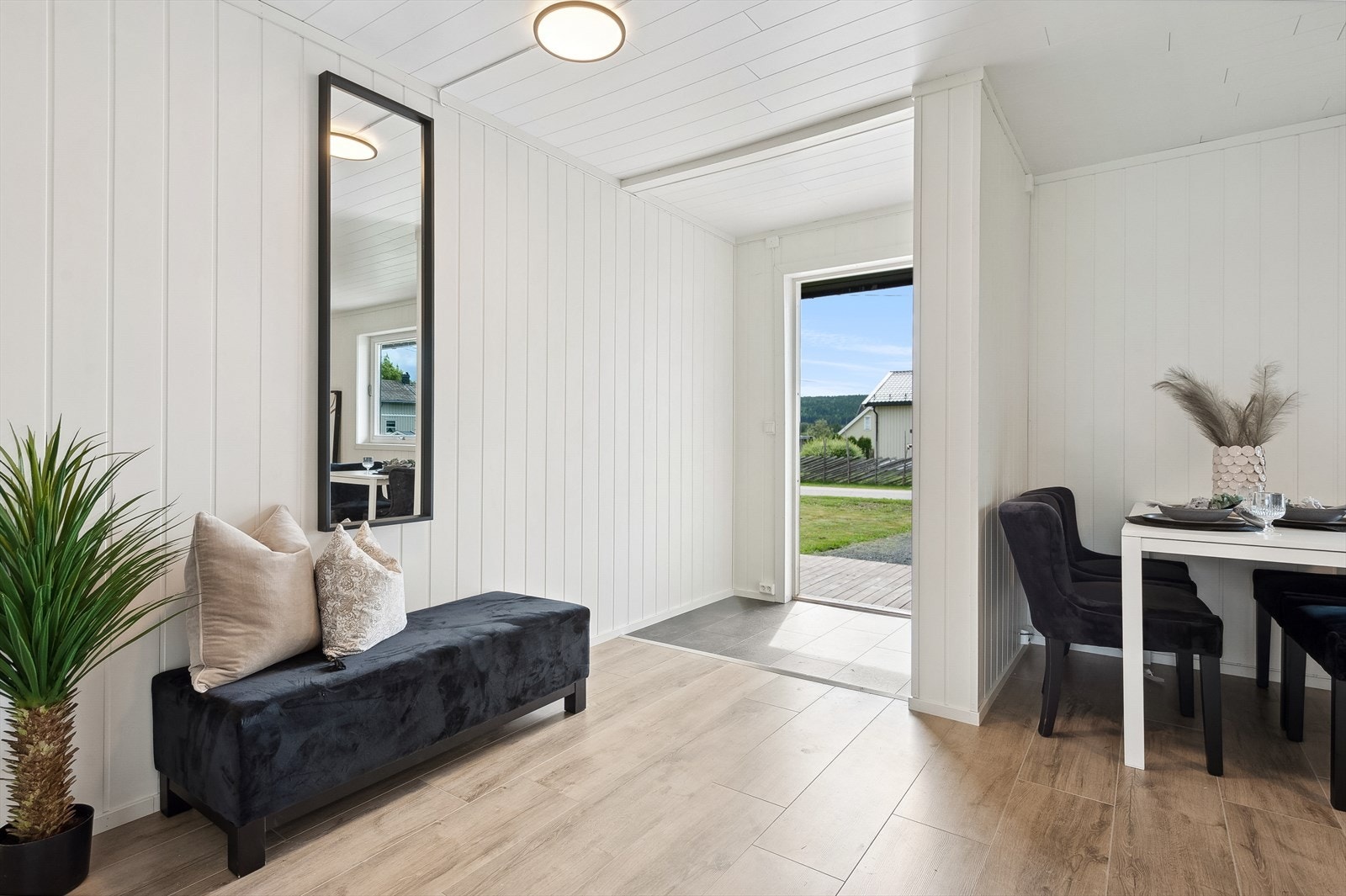 Når du entrer boligen kommer du inn i en praktisk entré med plass til sko og oppheng av yttertøy. Entréen har mørke fliser på gulv og lysmalte overflater. Galleribilde