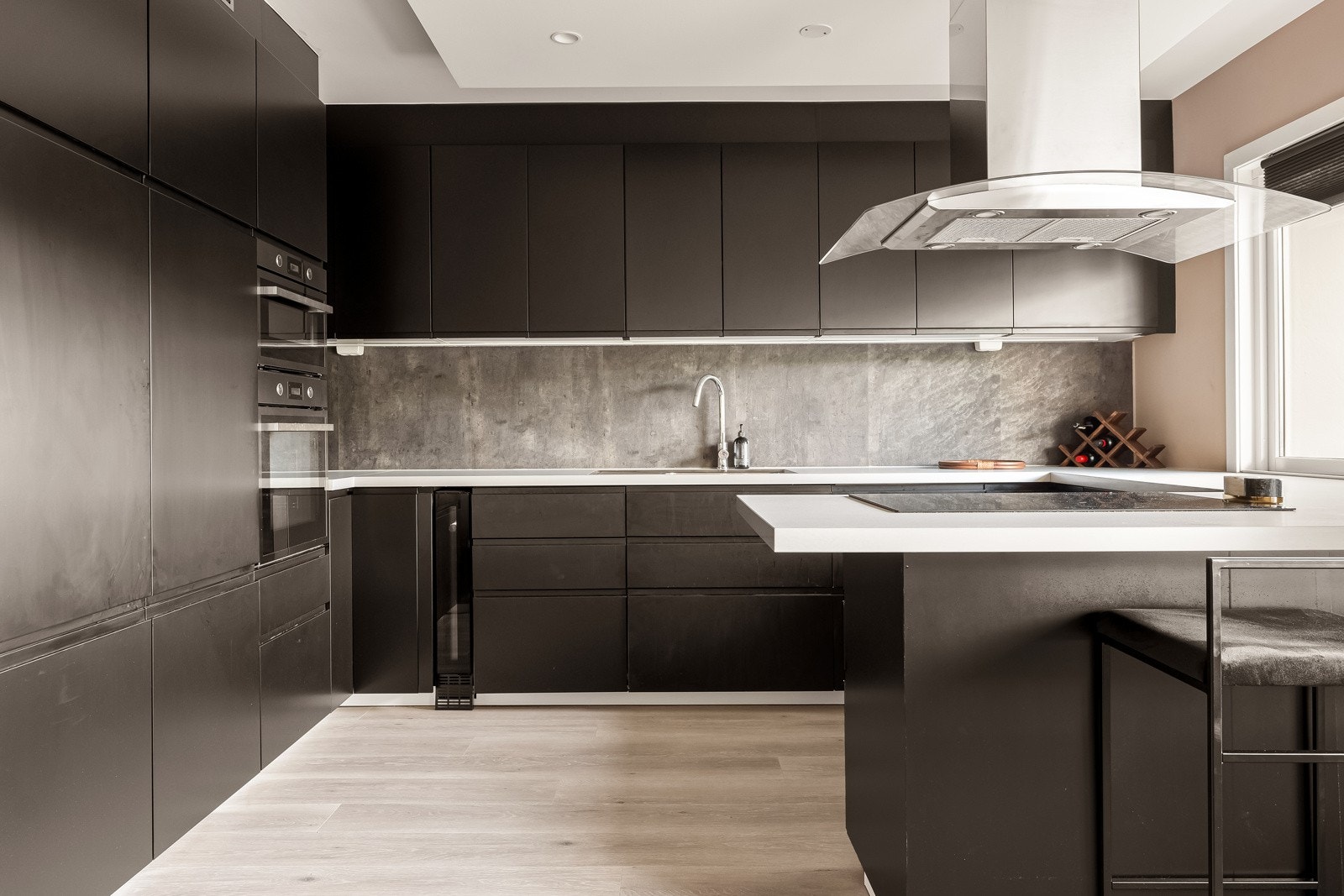 Stort og lekkert kjøkken med folierte fronter og integrerte hvitevarer Galleribilde