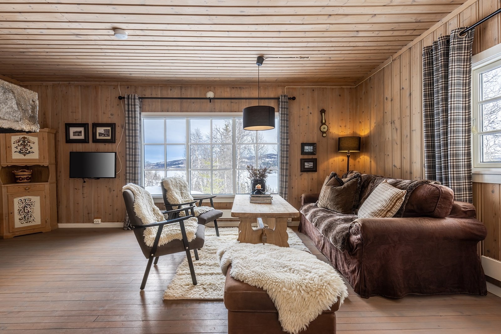 Hyggelig stue med store vindusflater som skaper en helt spesiell nærhet til omgivelsene rundt. Galleribilde