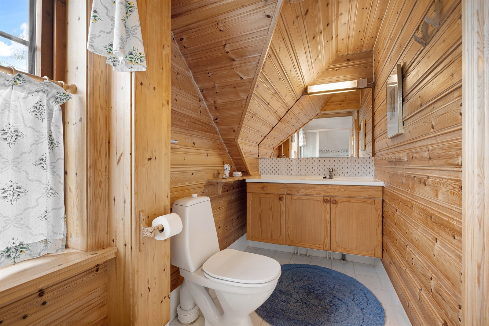 Eldre bad. Det er fliser på gulv med varmekabler, på vegger er det delvis panel og med fliser i dusjen Galleribilde