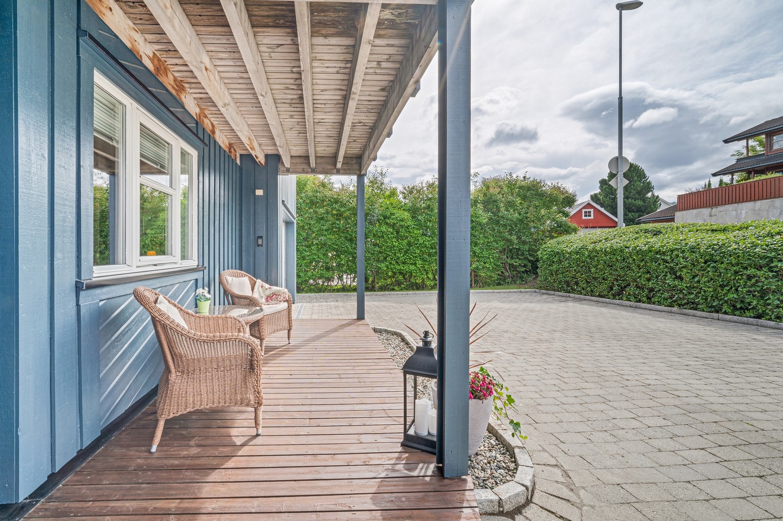 Innbydende inngangsparti med overbygd terrasse og steinbelagt gårdsplass. Rikelig med parkeringsplasser i gårdsplass og garasje. Galleribilde