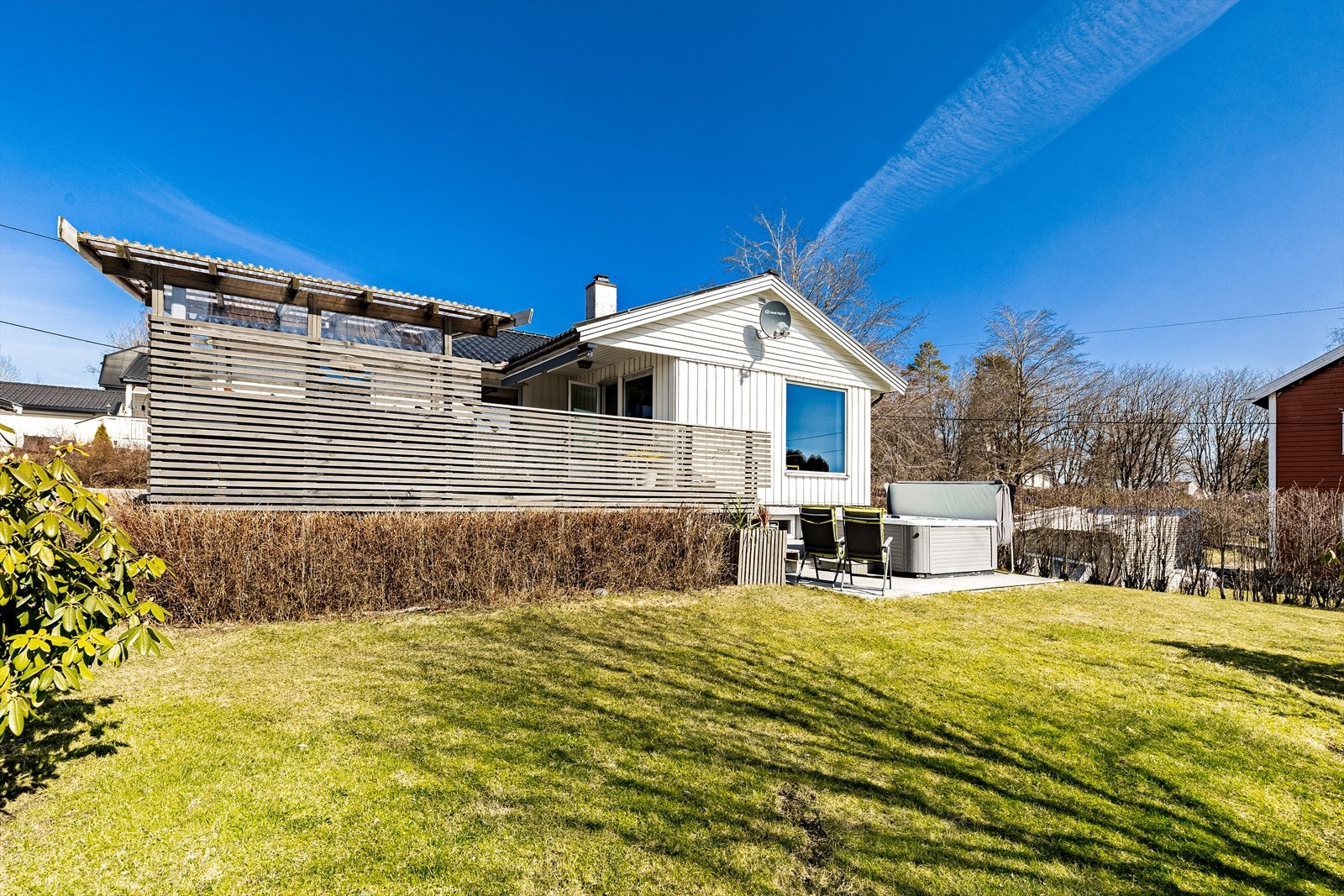 Hekk mot nabo på flere sider av boligen, som blir tett og skjermer for innsyn når den blomstrer Galleribilde