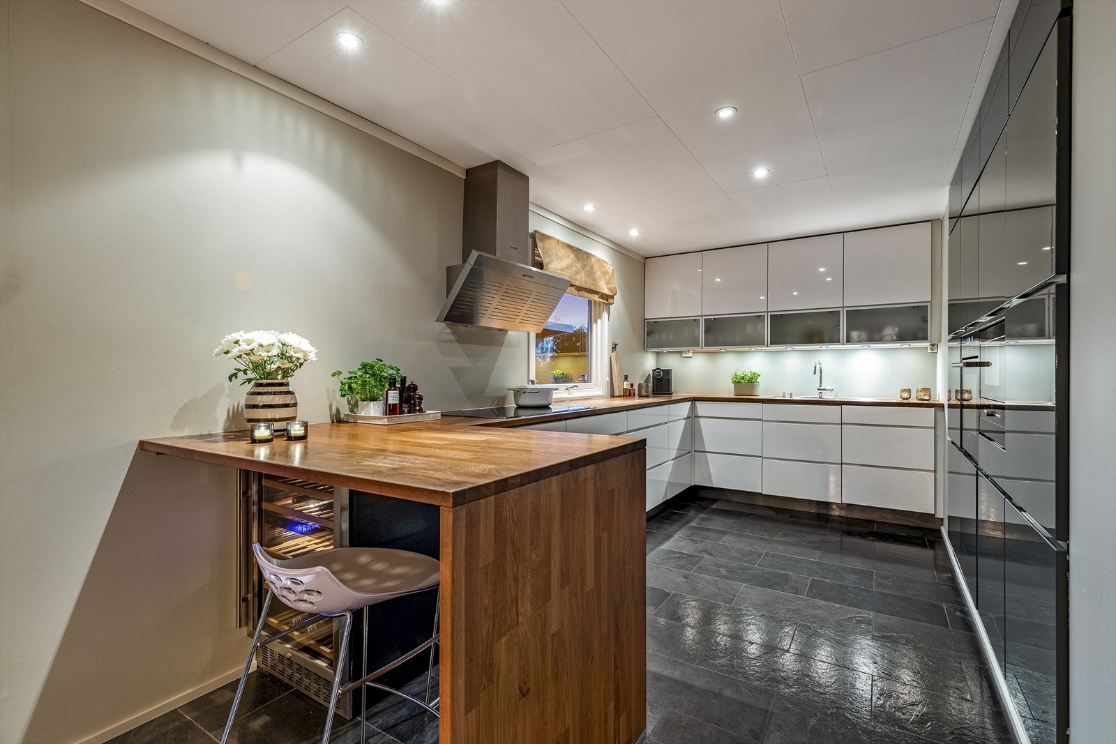 Flott kjøkken med innredning fra Kvik med glatte fronter og kjøkkenbenk i heltre Galleribilde