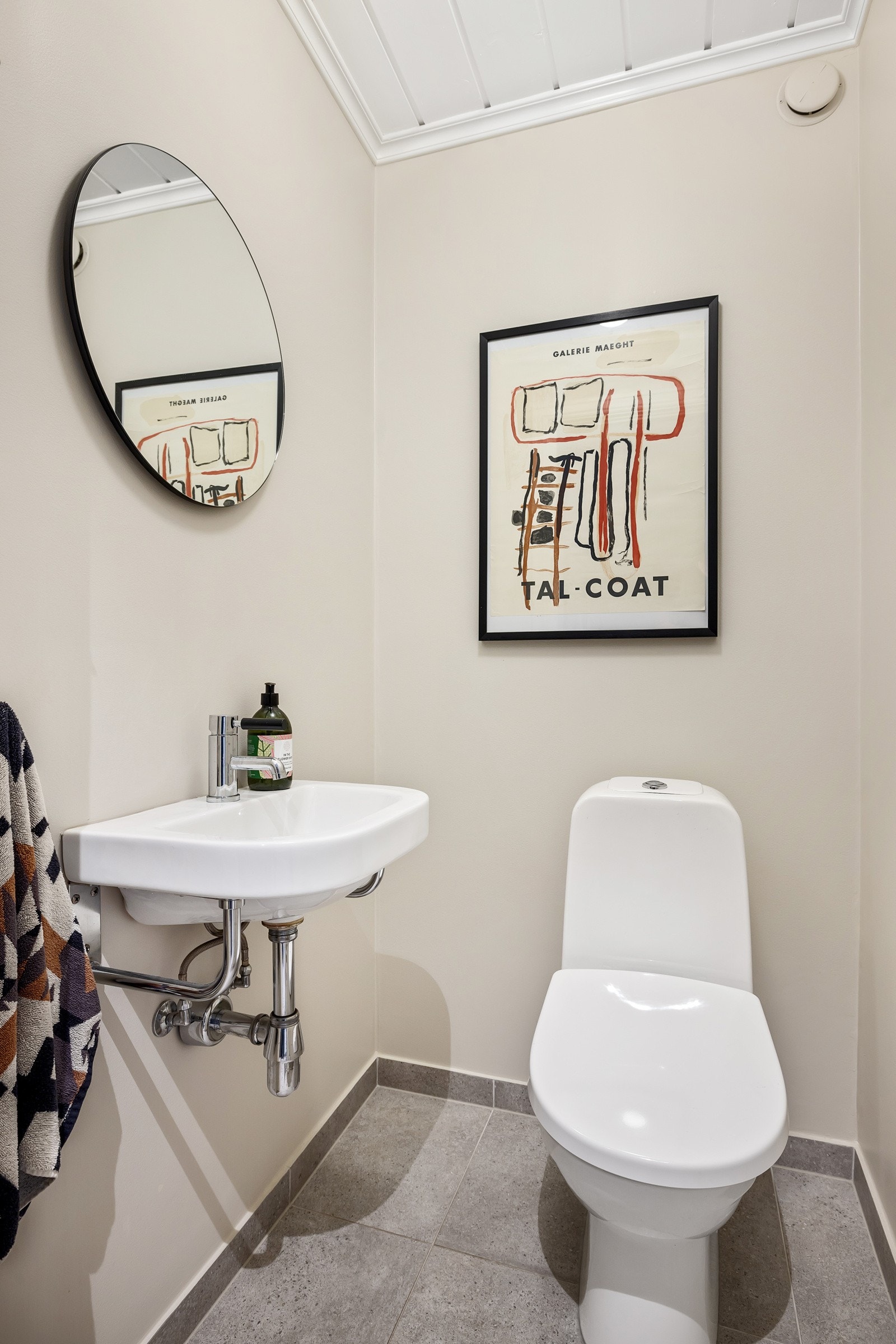 Praktisk gjestetoalett i hovedetasjen, innredet med klosett og servantinnredning. Fliser på gulv med gulvvarme Galleribilde