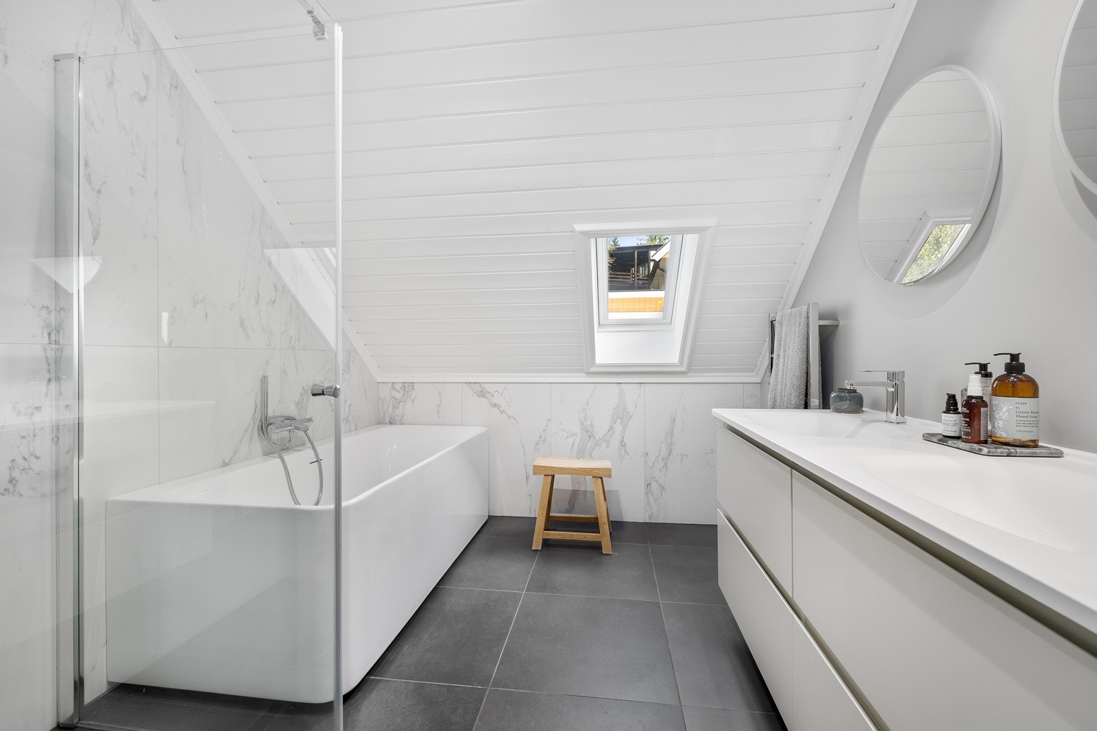 Stort baderom (rehabilitert i 2020), innredet med lyse fliser og downlights i taket. Galleribilde