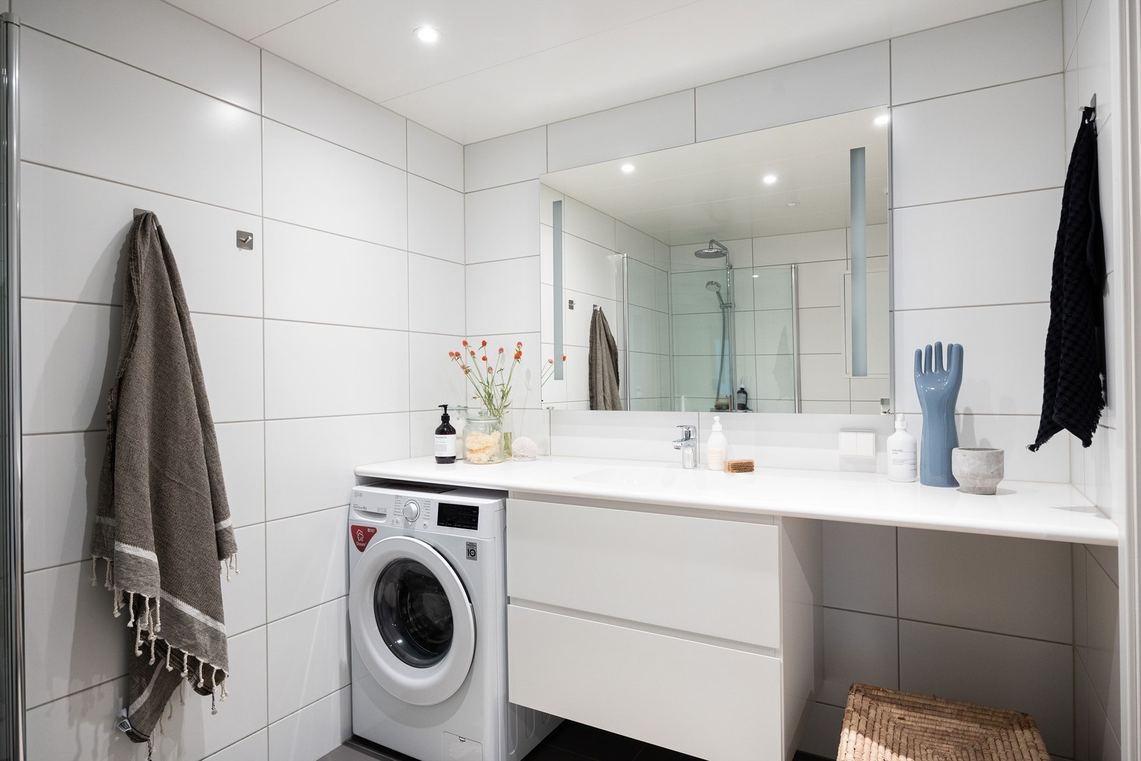 Videre er badet utstyrt med heldekkende servant med skuffeinnredning under og belyst speil over Galleribilde