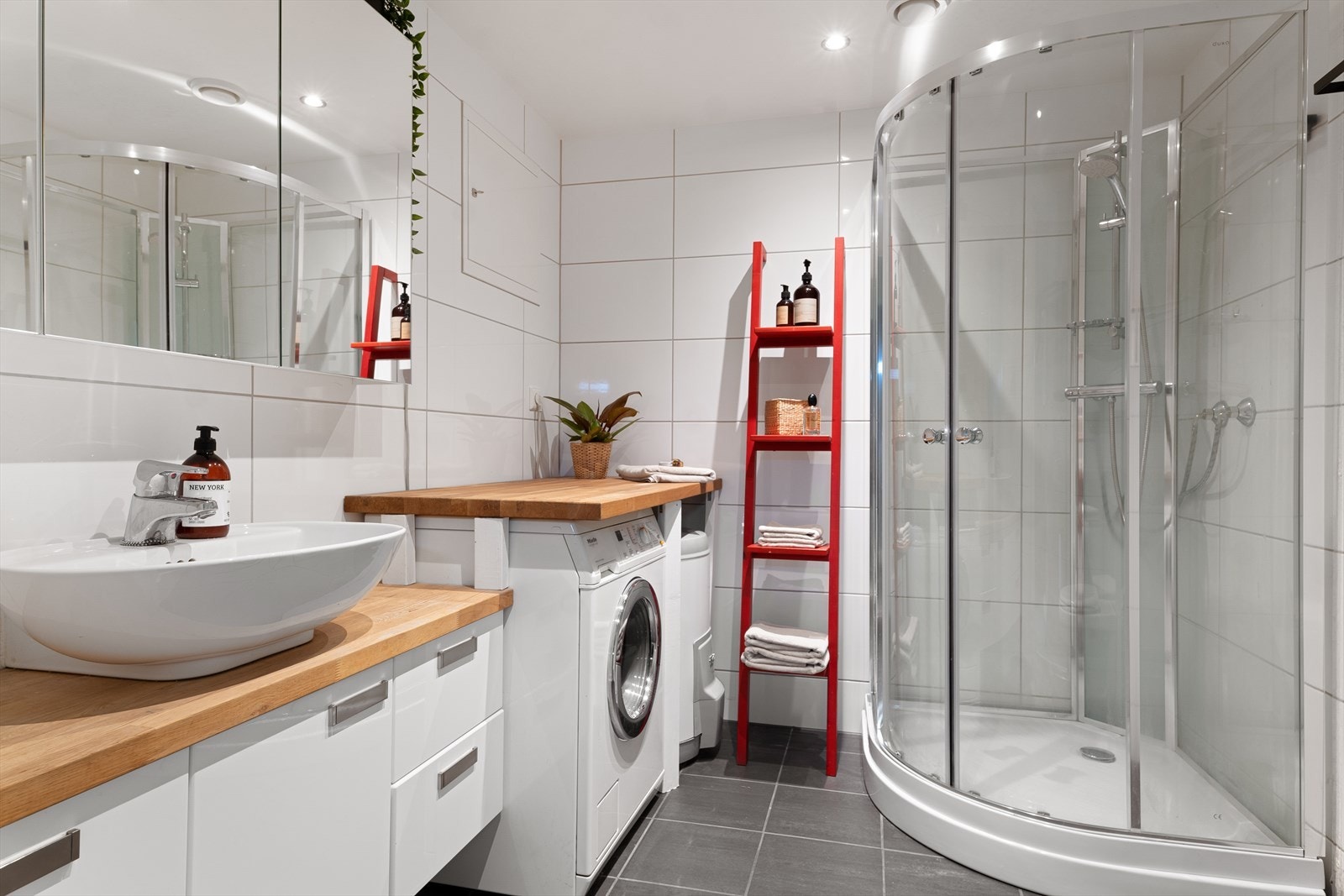 Speilskap, seksjon og god benkeplass. Tett dusjkabinett. Helflisede flater i tidløs utførelse. Galleribilde