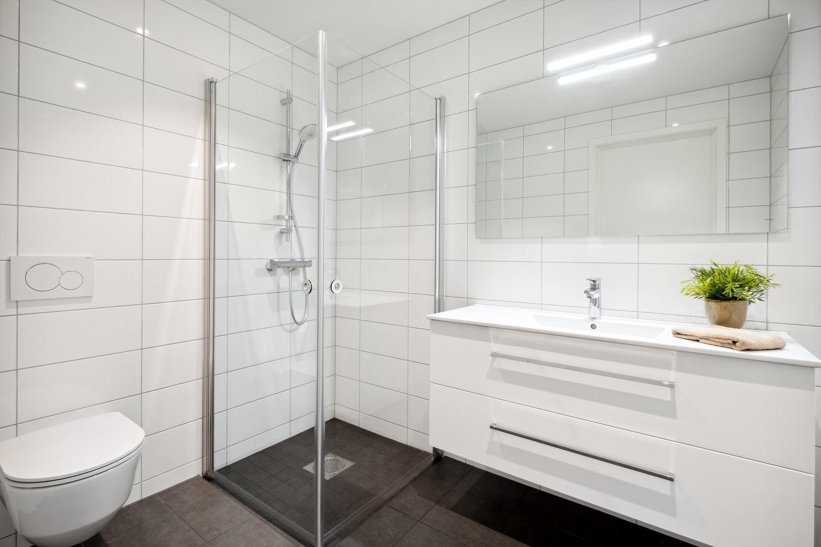 Bildet viser villaens andre bad. Dette badet er som det første badet: "lyst og lekkert", og det har også vegghengt toalett, samt servant med god oppbevaringsplass. Galleribilde