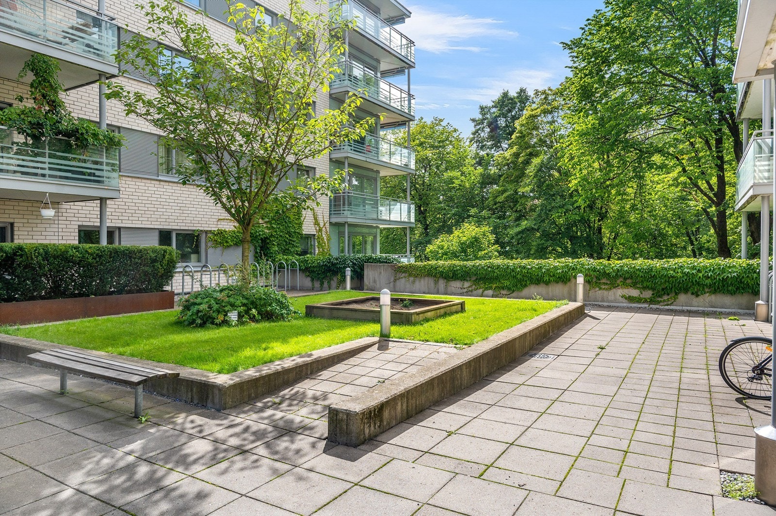 Rundt boligen er det hyggelige fellesarealer med benker, sykkelparkering, grøntarealer og diverse beplantning. Galleribilde