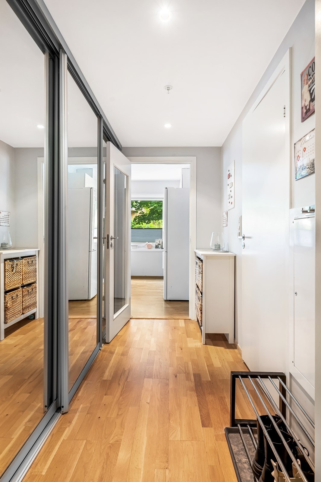 Fra entréen er det adkomst til bad, kjøkken og stue. Her er det god plass til oppbevaringsplass i en praktisk skyvedørsgarderobe med speilfronter. Galleribilde
