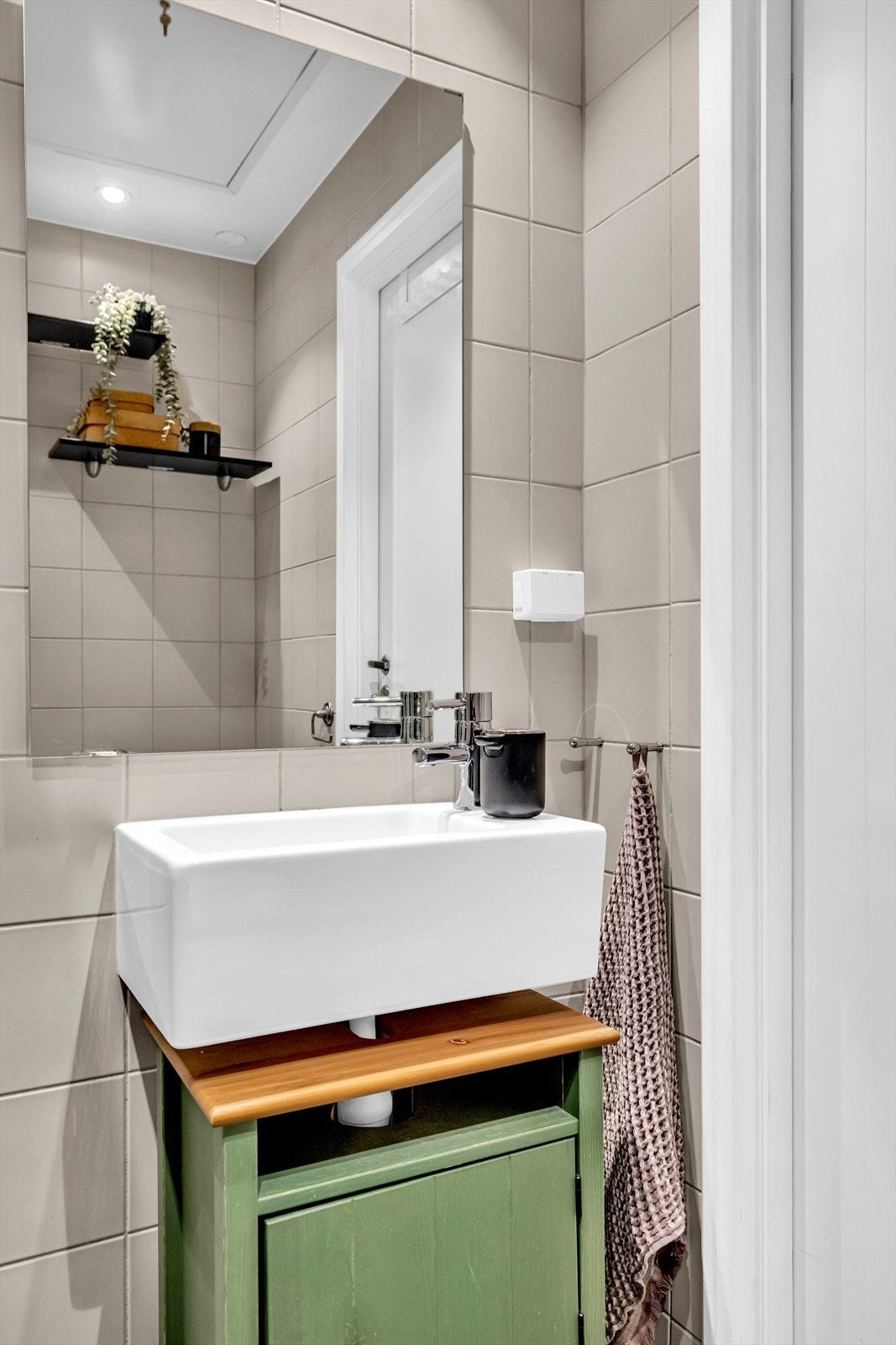 Innredningen består av servant, speil, gulvmontert toalett og opplegg for vaskemaskin Galleribilde