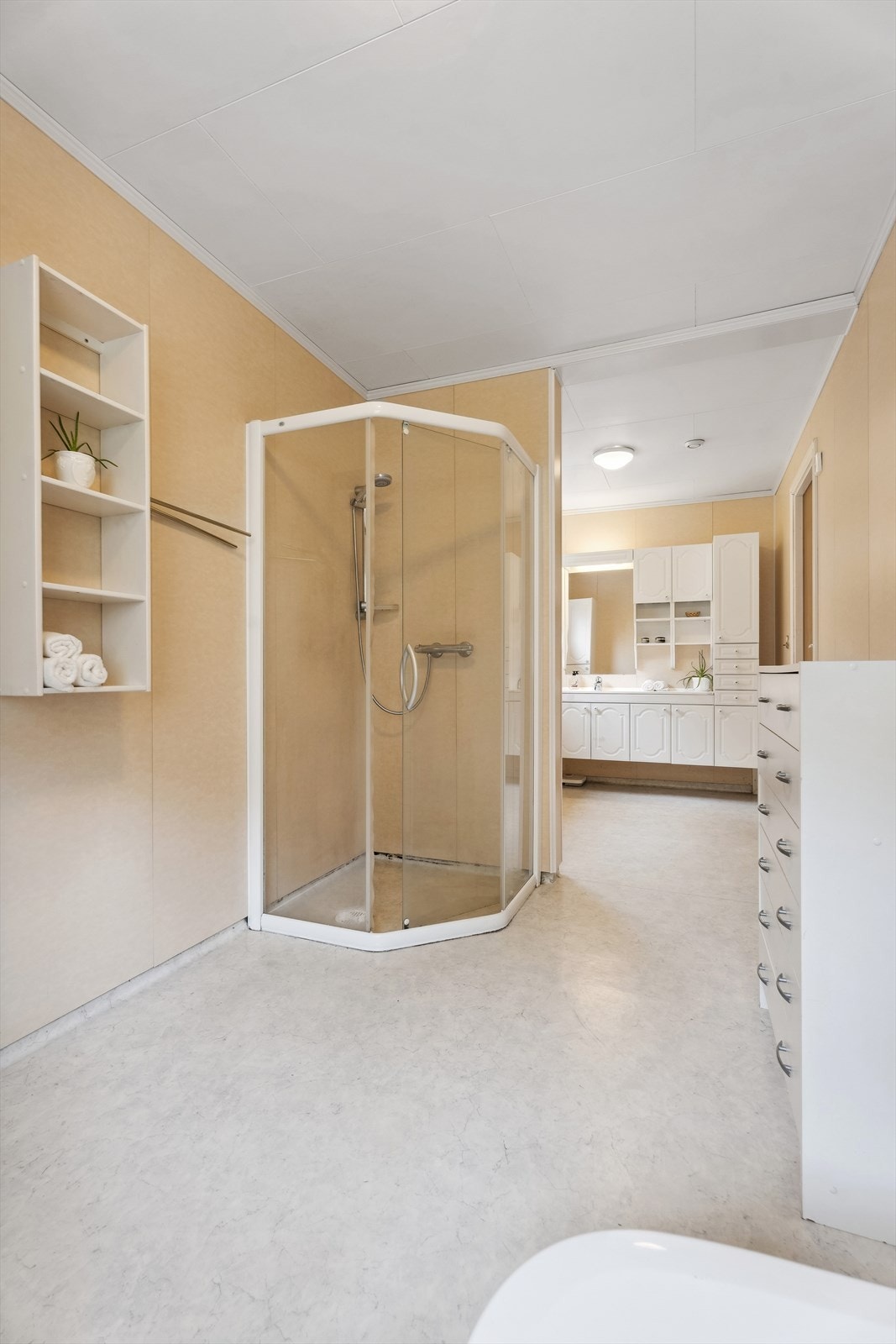 Eit særs romsleg bad, utstyrt med dusjkabinett og wc. Galleribilde