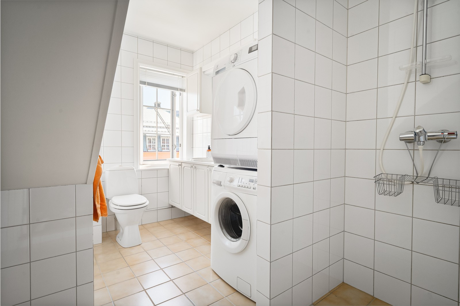 Badene er flislagt og i god størrelse, med plass til vaskemaskin og trommel.