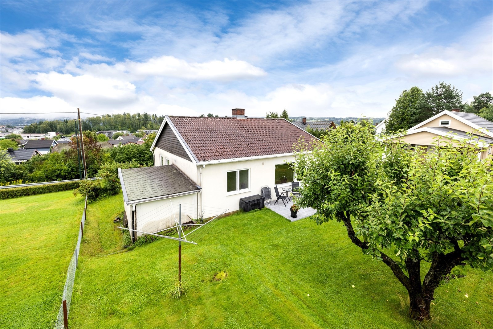 Hyggelig hage med gressplen, epletre og diverse beplantning. Galleribilde