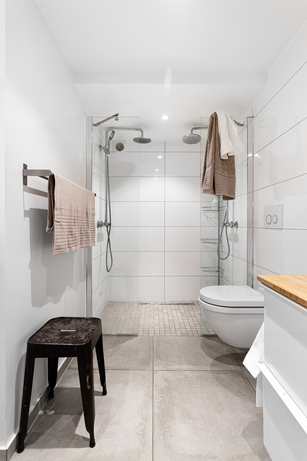 Badet er utstyrt med vegghengt wc, to servanter med skuffer under og dobbelt dusj i hjørnet med glassvegger. Det er også opplegg for vaskemaskin på dette badet. Galleribilde