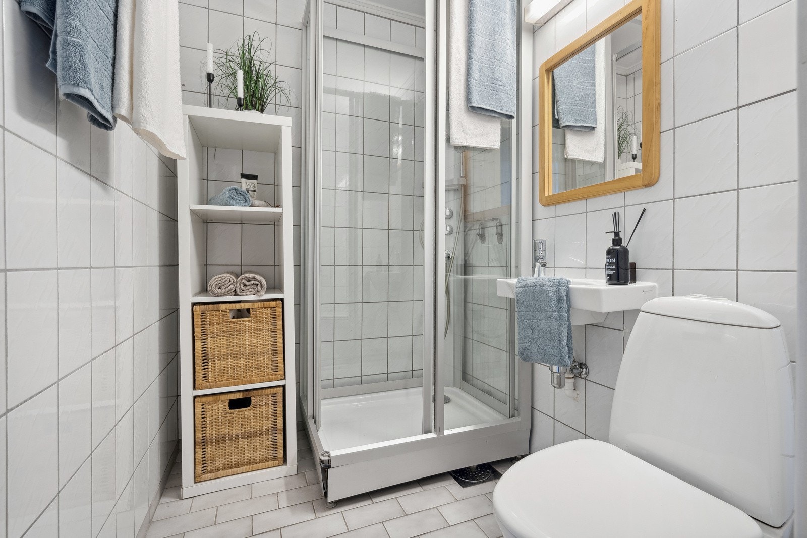 Flislagt baderom med gulvvarme, gulvstående toalett og dusjkabinett. Galleribilde