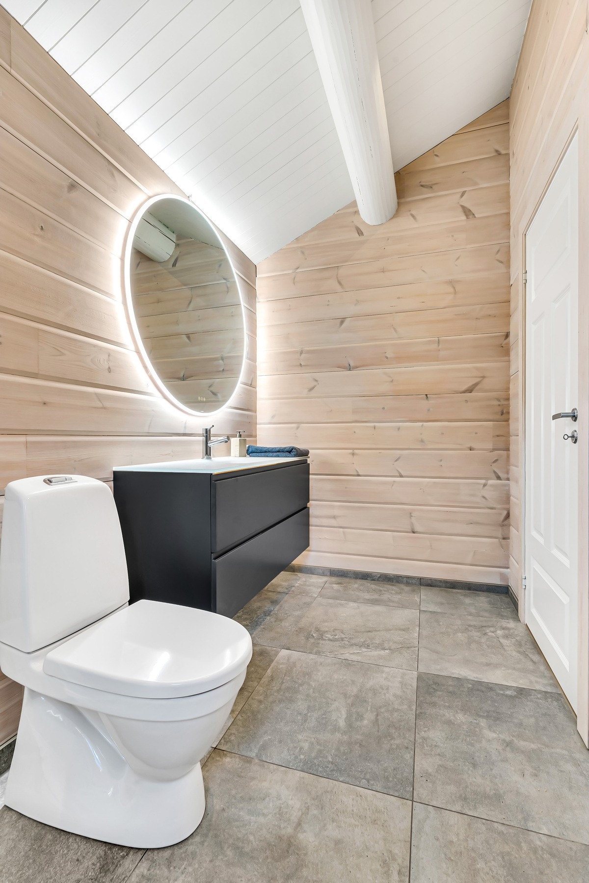 Badet har gulvmonter wc, mørkt lekker servant og dusjkabinett. Galleribilde