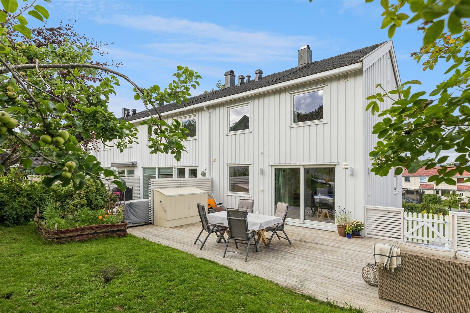 Pent opparbeidet hage med blant annet blodbøk, blomsterbed, plen og epletre. Galleribilde