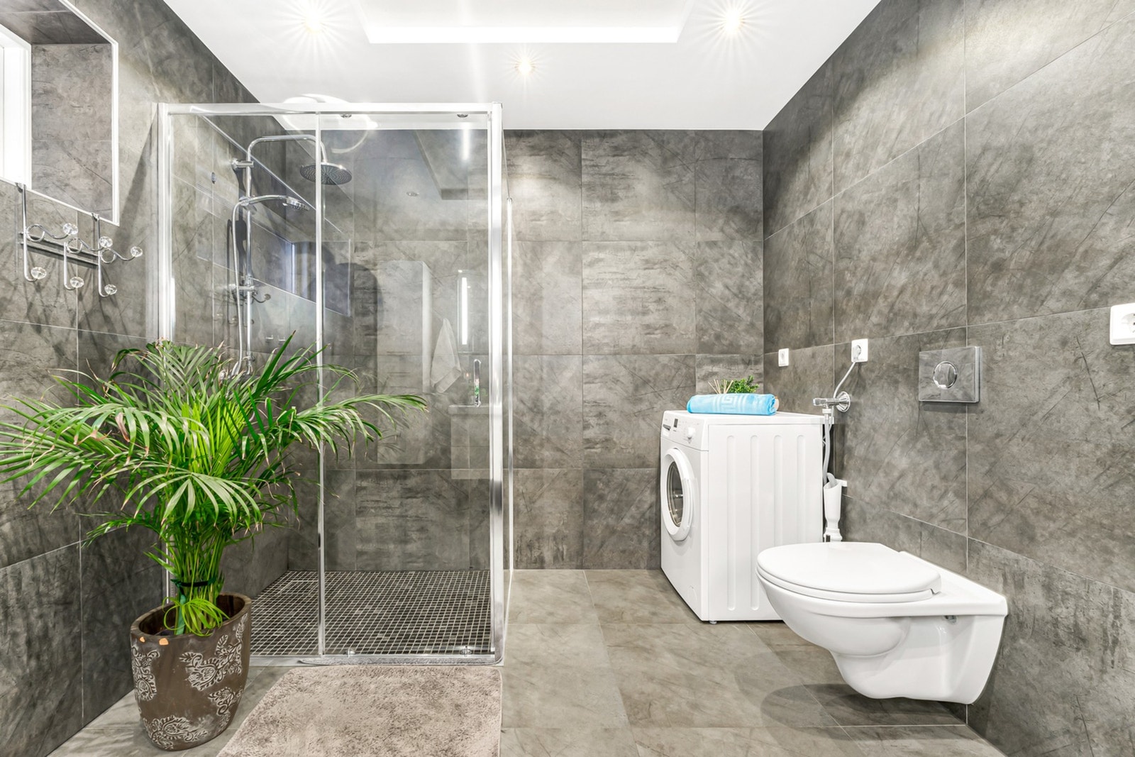 Badet har vegghengt toalett, dusjhjørne, baderomsinnredning og opplegg til vaskemaskin. Galleribilde