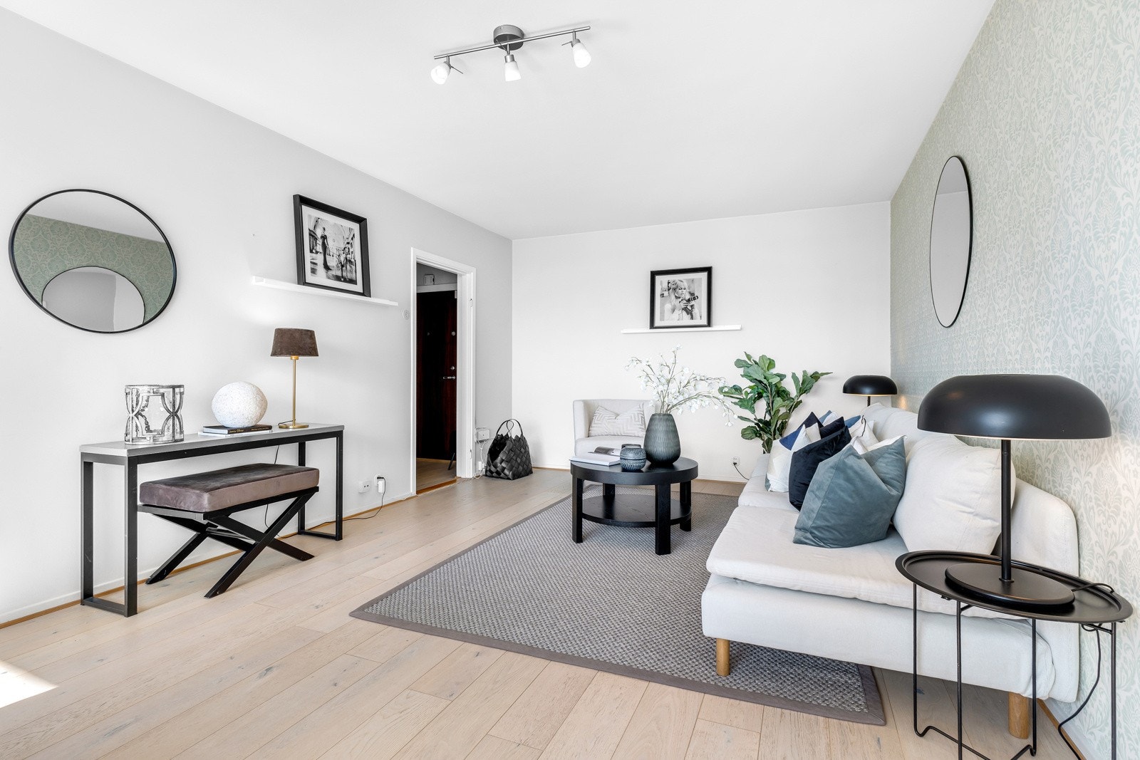 Rommet har lekker enstavs hvitpigmentert eikeparkett på gulvet, og hvitmalte veggflater samt tapet Galleribilde