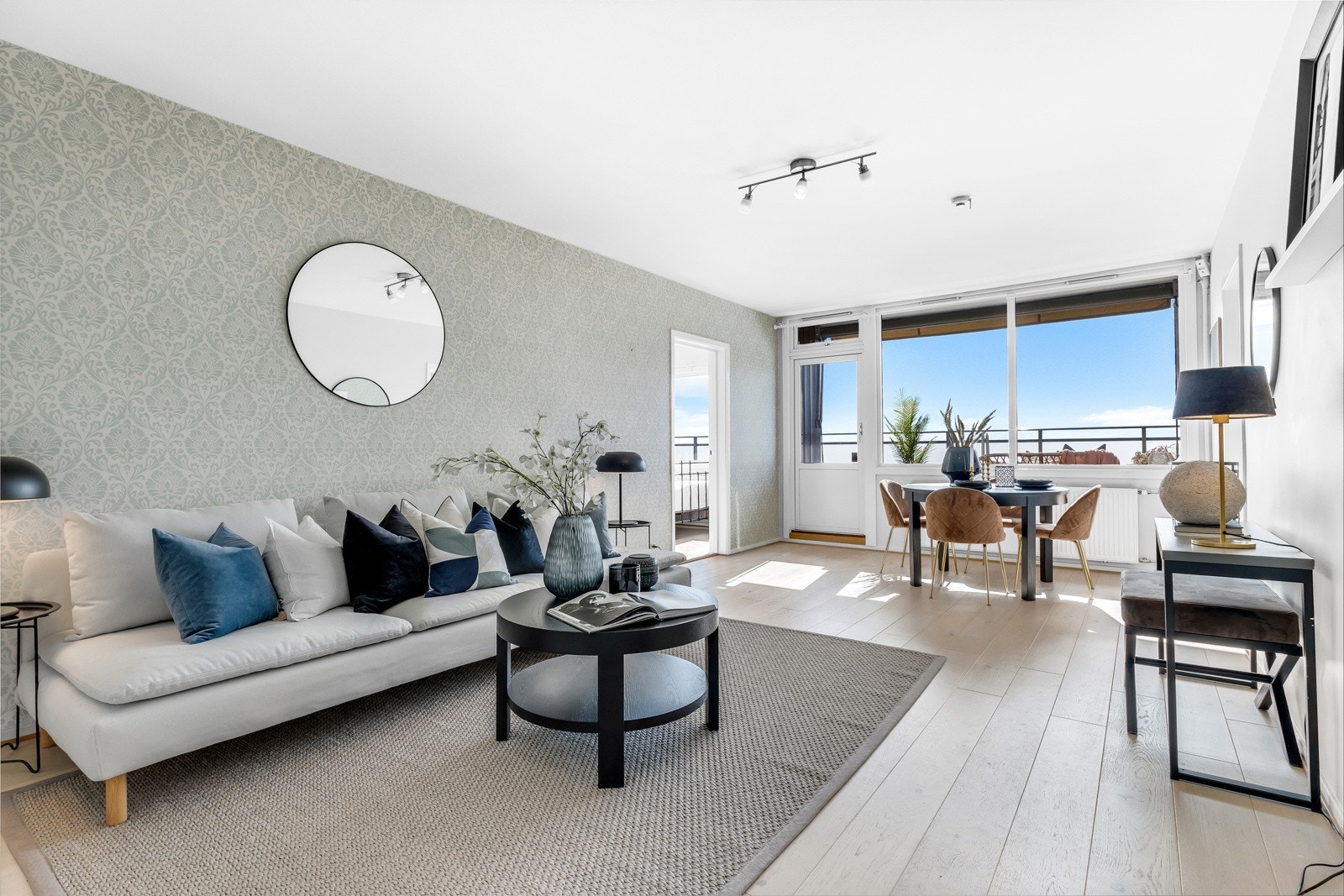 Tiltalende stue med godt lysinnslipp fra store vindusflater, og fra glassdør mot balkong Galleribilde