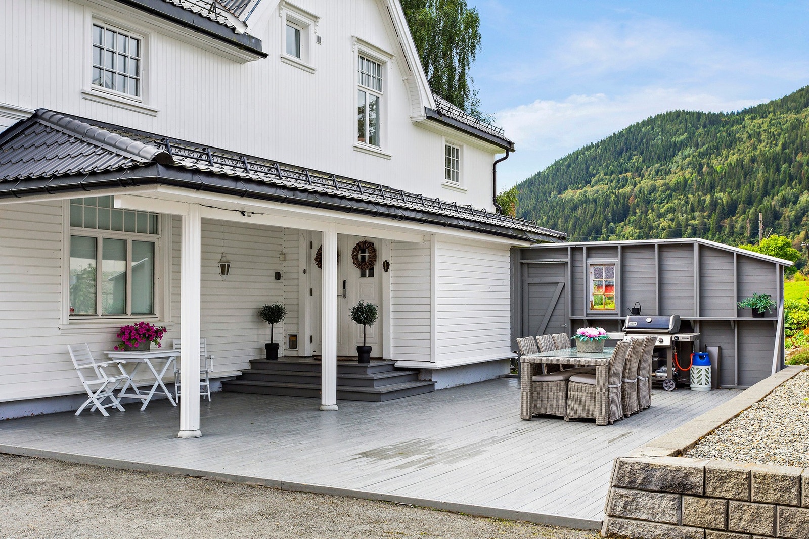 Takoverbyggd inngangsparti og nordvendt terrasse med vindskjerming og god plass til stor sittegruppe samt grillmuligheter. Galleribilde