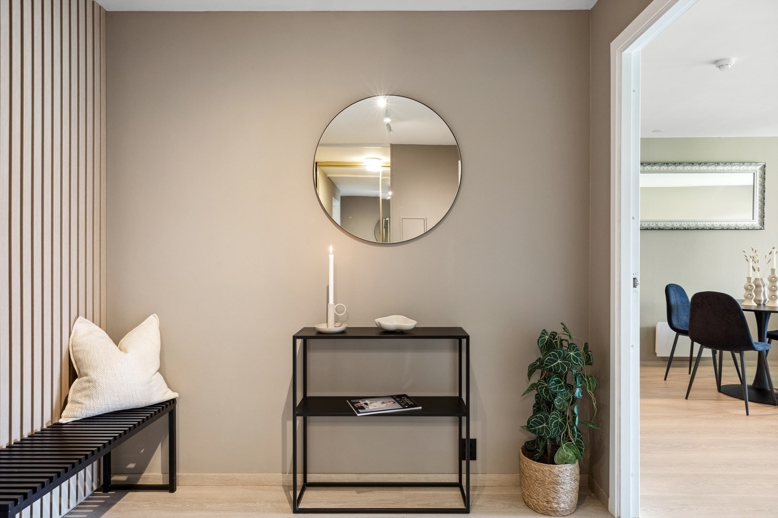 Den ene veggen i entreen er kledd med spiler på sort bakgrunn. Galleribilde