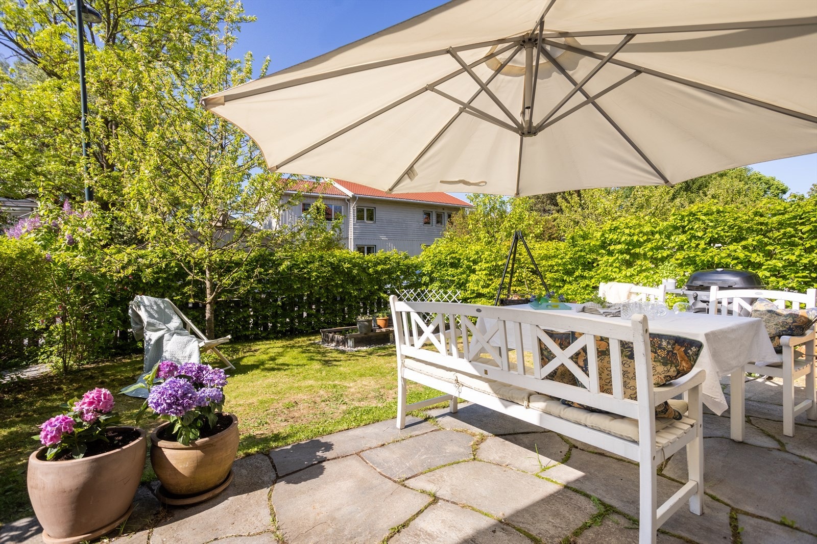 Hagen er omkranset av vakker beplantning som skaper en skjermet og frodig oase. Galleribilde