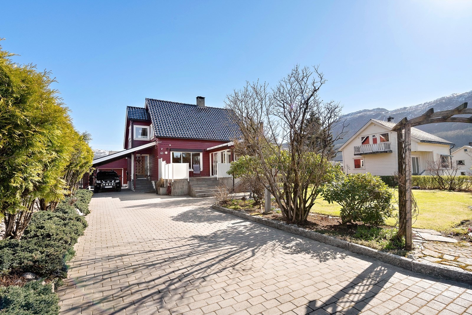 Meget flott opparbeidet tomt med belegningsstein, blomsterbed og plen Galleribilde