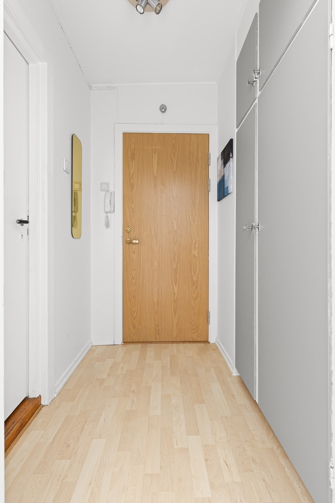 Lys entré hvor du enkelt kan henge i fra deg yttertøy og sko i innfelt garderobeskap med oppheng. Galleribilde