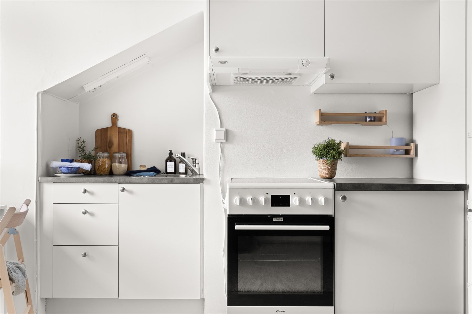 Videre er det frittstående kjøl/fryseskap, oppvaskmaskin og komfyr med platetopp og kullfiltervifte over stekesonen. Galleribilde