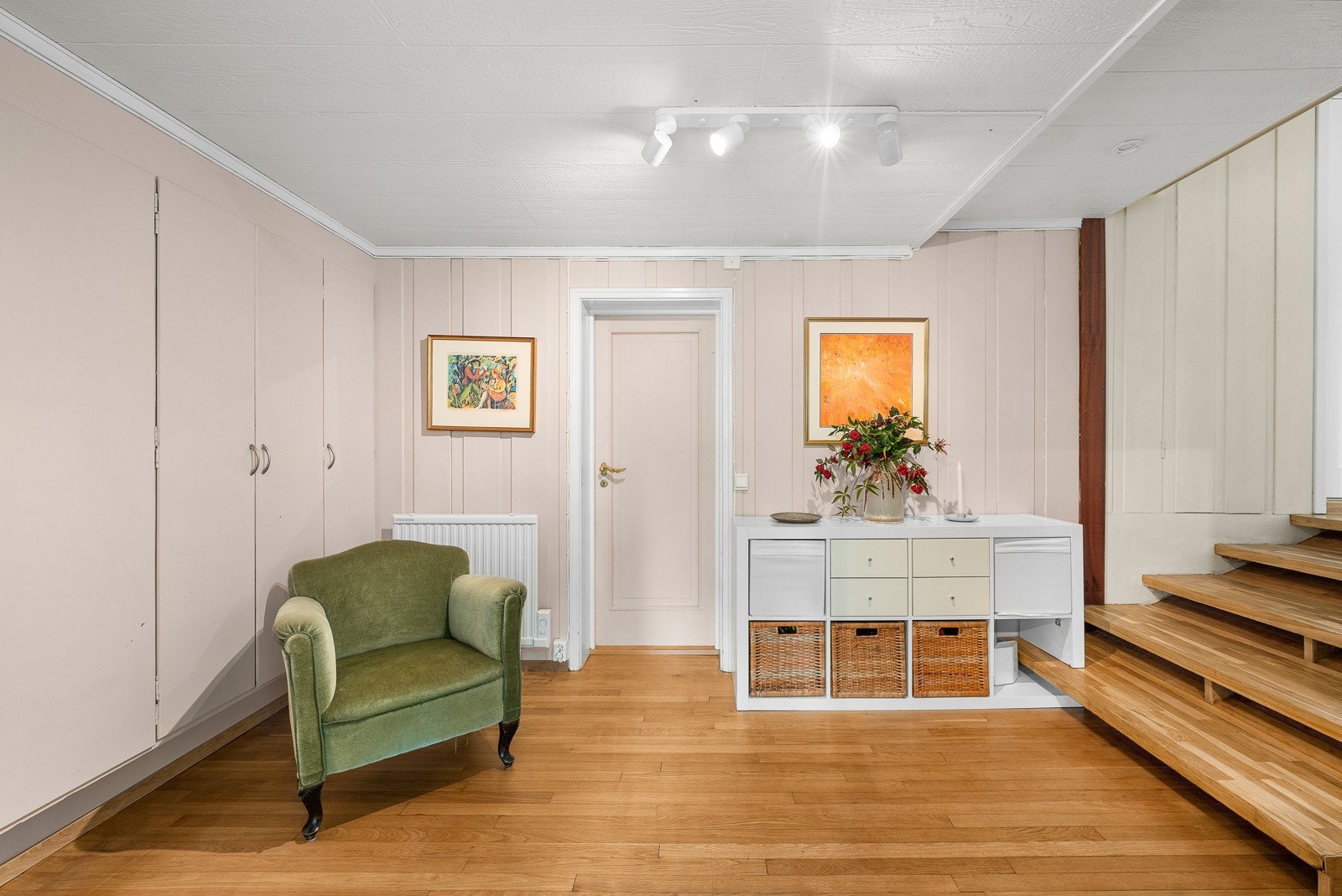 Entreen har også plass til stol og kommode. Gulvet har parkett og veggene har malt panel. Fra entreen er det dør til et kontor/gjesterom, samt trapp opp til stue/kjøkken som ligger et halvplan høyere. Galleribilde