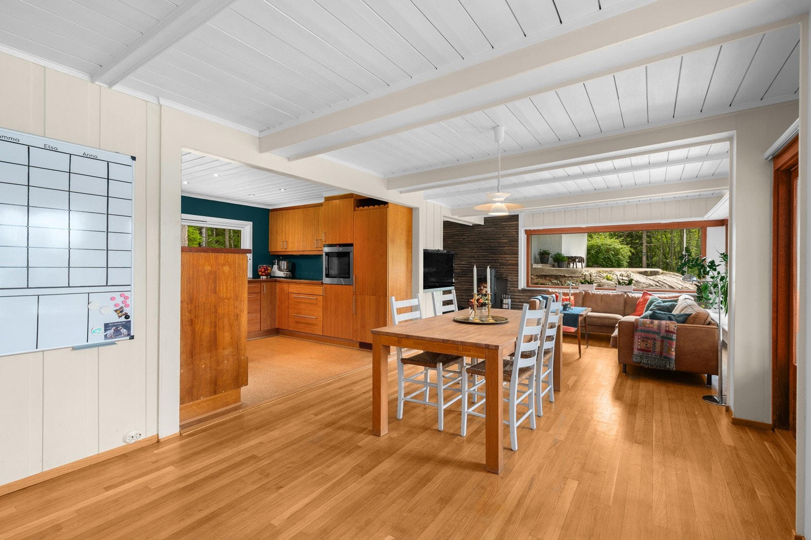 Boligen har stue og kjøkken i åpen løsning, med store vinduer som gir fin kontakt med naturen Galleribilde